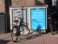 851076 Afbeelding van een affiche met de tekst 'Ondersteun jouw lokale ondernemer, vooral nu', op een schakelkast bij ...